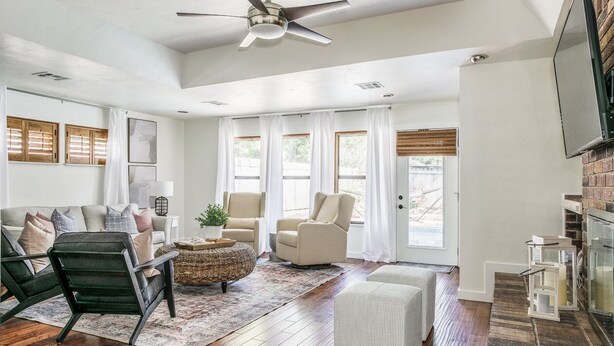 A spacious living room with a ceiling fan, a sofa set, a coffee table, and a fireplace. - Cozy 3 bdrm w/pool & hot tub!! (Oklahoma City)
