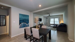 A modern living room with a dining area, a flat-screen TV, and a ceiling fan. - New Modern home only 11 miles from Downtown and the Pearl Brewery! (Converse)