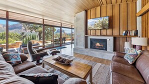 A spacious living room with a large window, a fireplace, and a comfortable seating area. - Specials: Lux Escape | Pool, Hot Tub, Epic Views (Sedona)