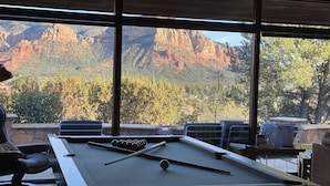 A pool table with a mountain view through large windows. - Specials: Lux Escape | Pool, Hot Tub, Epic Views (Sedona)