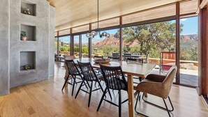 A dining area with a large table and chairs, a wooden ceiling, and a view of the outdoors. - Specials: Lux Escape | Pool, Hot Tub, Epic Views (Sedona)
