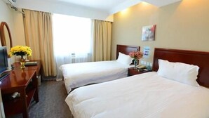 A hotel room with two single beds, a desk with a computer, a vase with flowers, and a window with curtains. - Greentree Inn Shaoxing Binhai New City Dongsen Commercial Square Hotel (Shaoxing)