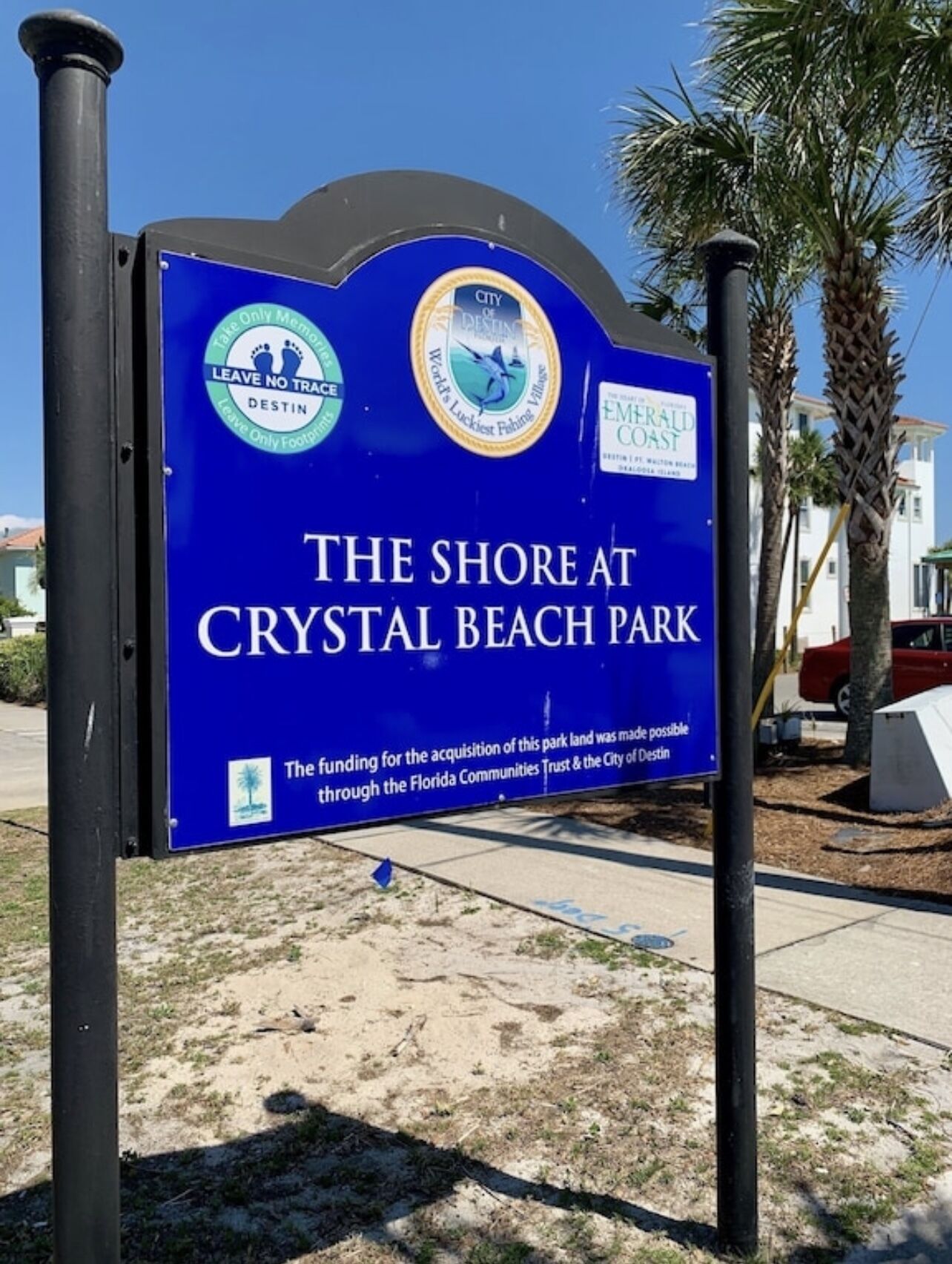 A sign for Crystal Beach Park with logos for 'Tale of the City' and 'City of Destin'.