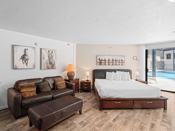 Ein Schlafzimmer mit einem Bett, einem Ledersofa und zwei Wandleuchten.