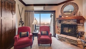 Un salón con dos sillones rojos, una chimenea y un espejo grande en la pared.