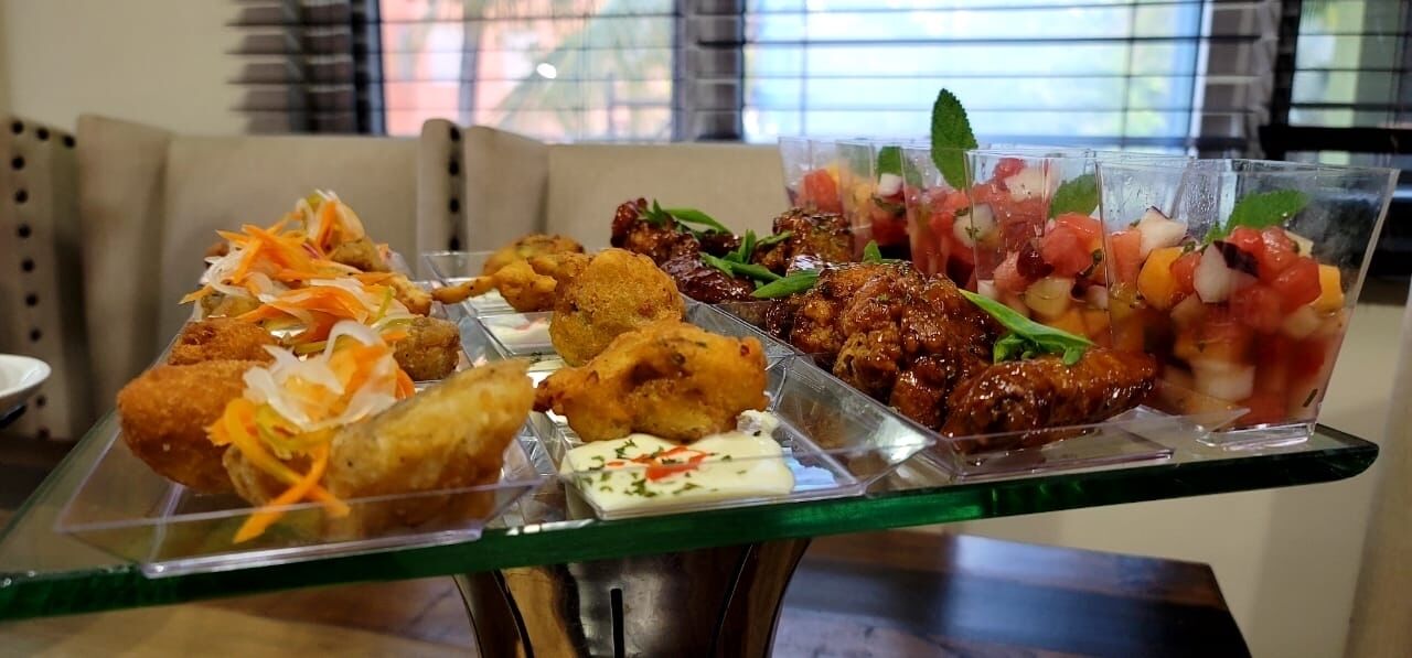 A buffet table with various dishes including fried items, salads, and a drink.