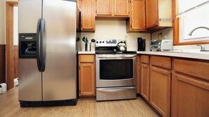 Una cocina con armarios de madera, un refrigerador de acero inoxidable, un horno y un tostador.