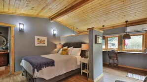 A bedroom with a bed, bedside table, lamp, chair, and window. - The Ridge at Langley: Villa Oscar (Langley)