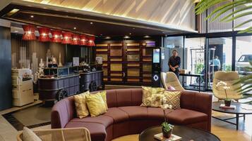 A modern lobby with a reception desk, seating area, and a large window.
