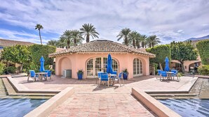 Un cortile con piscina, area relax all'aperto e palme.