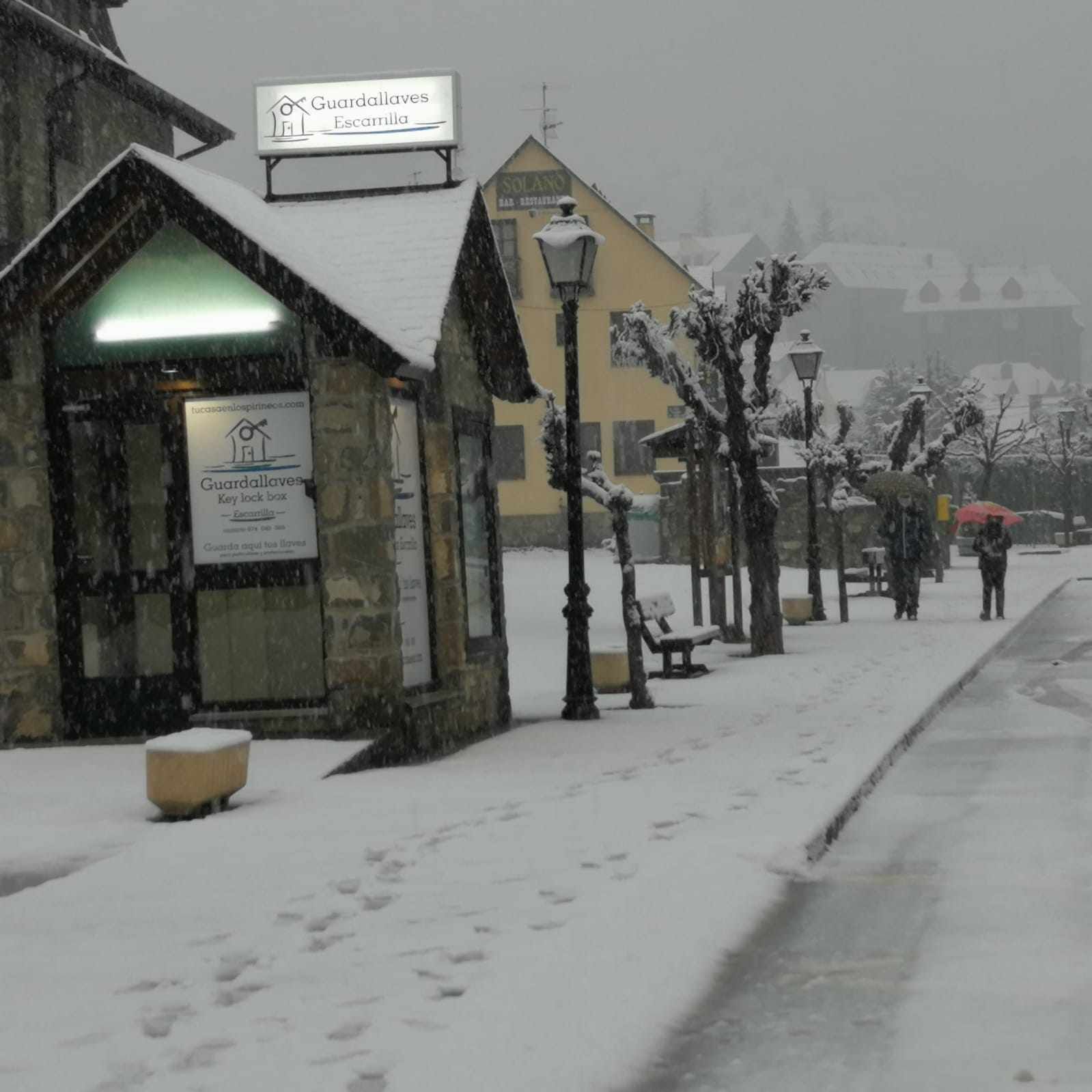 A snow-covered street with a building labeled 'Guardallaves Escamilla' and a sign for 'lucasaenospinoline.com'.