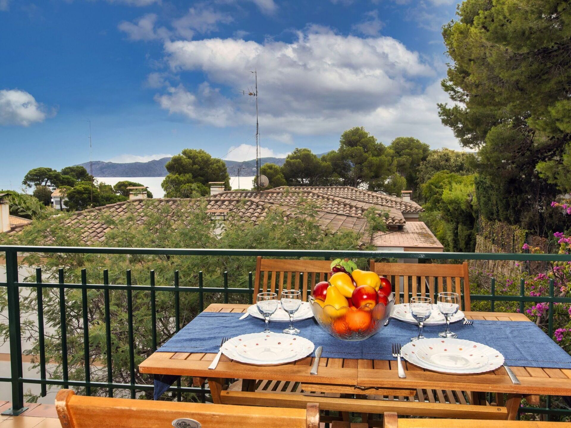 A table set outdoors with a view of a mountainous landscape and a body of water.