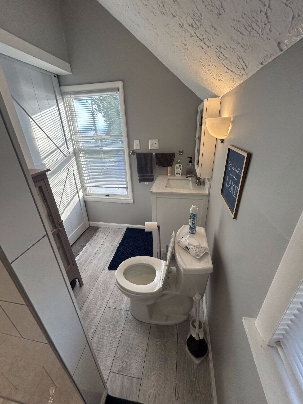 Un baño con inodoro, lavamanos y ventana.