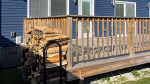 Ein blauer Wohnwagen mit einer Holzterrasse und einem Holzstoß.