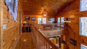 A cabin with wooden walls, a balcony, and a ceiling fan. - Stress Re-Leaf - Blowing Rock Cabin with great view, hot tub, pool table (Lenoir)