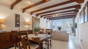 A dining area with wooden furniture, a table with a placemat, and a view to the outside.