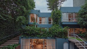 Un edifici modern de dues plantes amb façana corbada, grans finestres i un balcó.