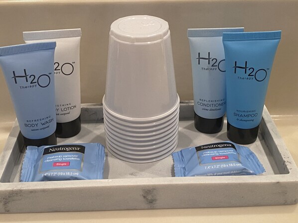 A tray with various H2O Therapy products including body wash, lotion, and shampoo.
