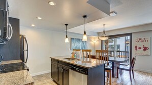 A modern kitchen with granite countertops, stainless steel appliances, and pendant lighting. - 3BR, 1250SQFT, NATURE, HOT TUB, KING BEDS, PETS OK (Dead Man's Flats)