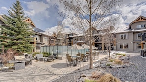 A patio area with outdoor seating, a grill, and a large umbrella. - 3BR, 1250SQFT, NATURE, HOT TUB, KING BEDS, PETS OK (Dead Man's Flats)