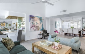 A spacious living area with a modern design, featuring a large coffee table, comfortable seating, and a dining area with a white table and chairs. - Casual Elegance in the Desert | A Louisa Davis Property (Rancho Mirage)