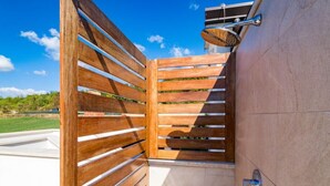 Une porte en bois avec des traverses horizontales, une poignée en métal et un petit luminaire fixé au-dessus.