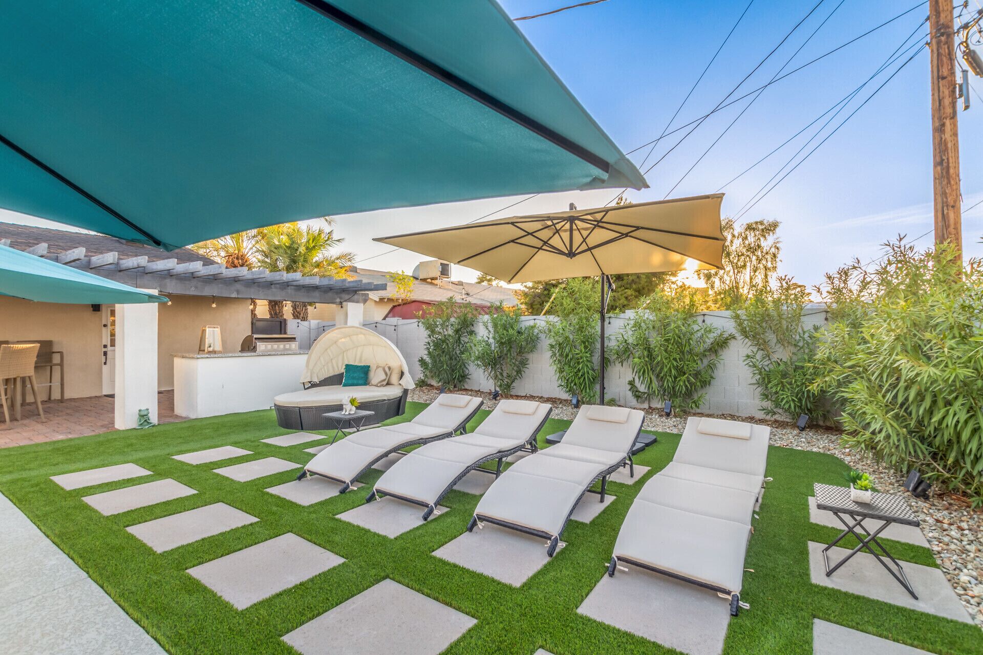 Un jardin avec un espace patio comprenant un canapé, une table à manger et un barbecue.