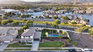 A residential area with houses, a swimming pool, and a river.