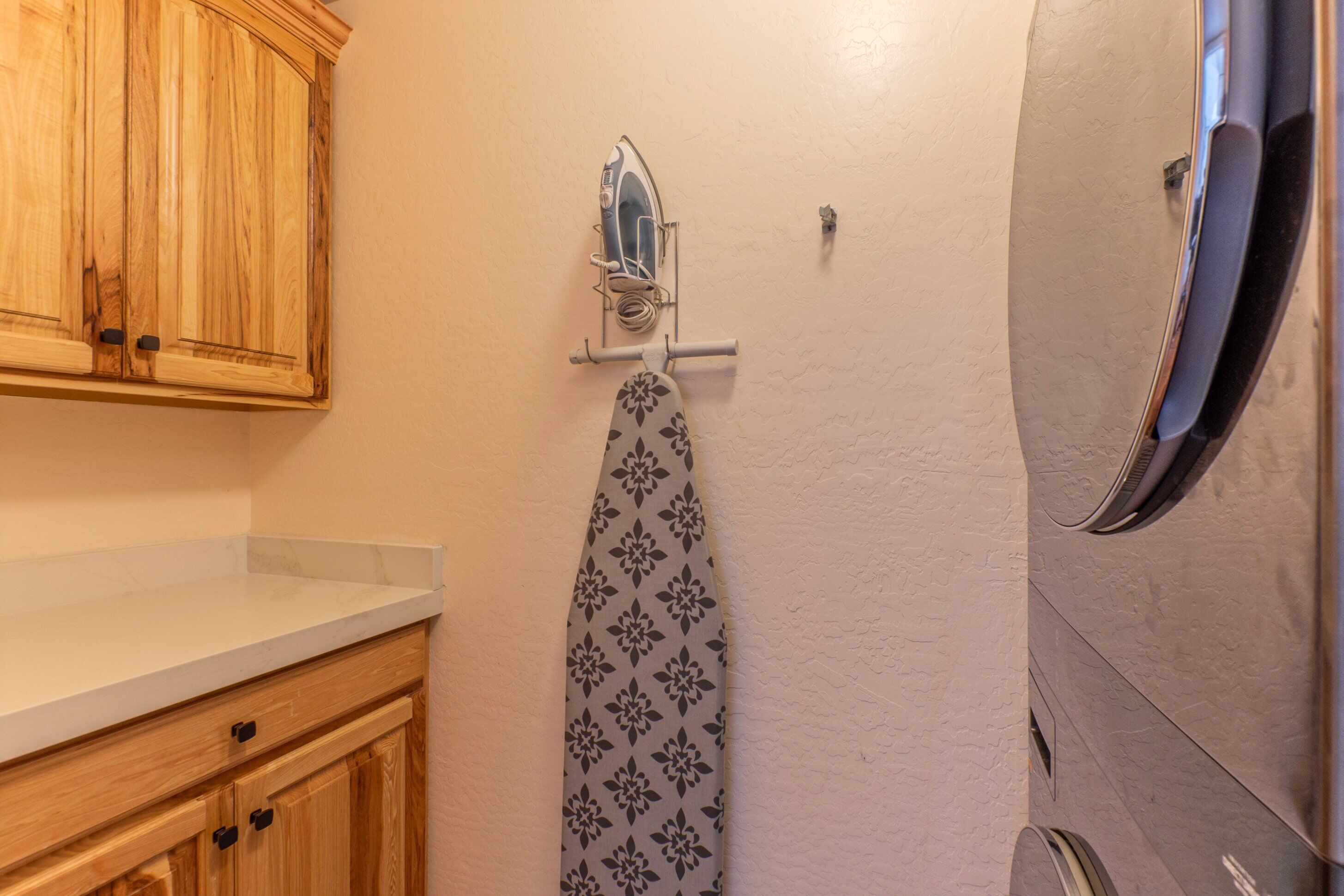 A bathroom with wooden cabinets, a towel rack with a patterned towel, and a mirror.