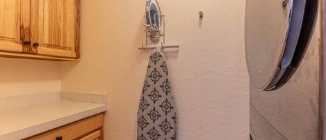 A bathroom with wooden cabinets, a towel rack with a patterned towel, and a mirror.