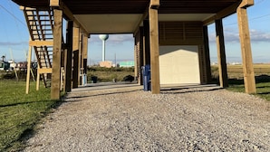 Une construction en bois à deux étages, dotée d’un balcon, d’un garage et d’une enseigne indiquant : « AMUSEMENT GARANTI à la plage de Surfside ».