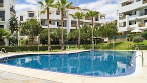 A modern apartment complex with a swimming pool, palm trees, and a clear blue sky. - Apartment Alamar by Interhome (Mijas Costa)