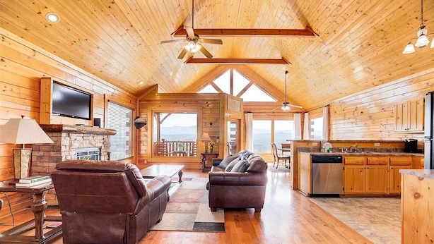 A spacious wooden cabin interior with a living area, kitchen, and large windows offering views. - Majestic Smoky Mountains Views | HotTub (Sevierville)