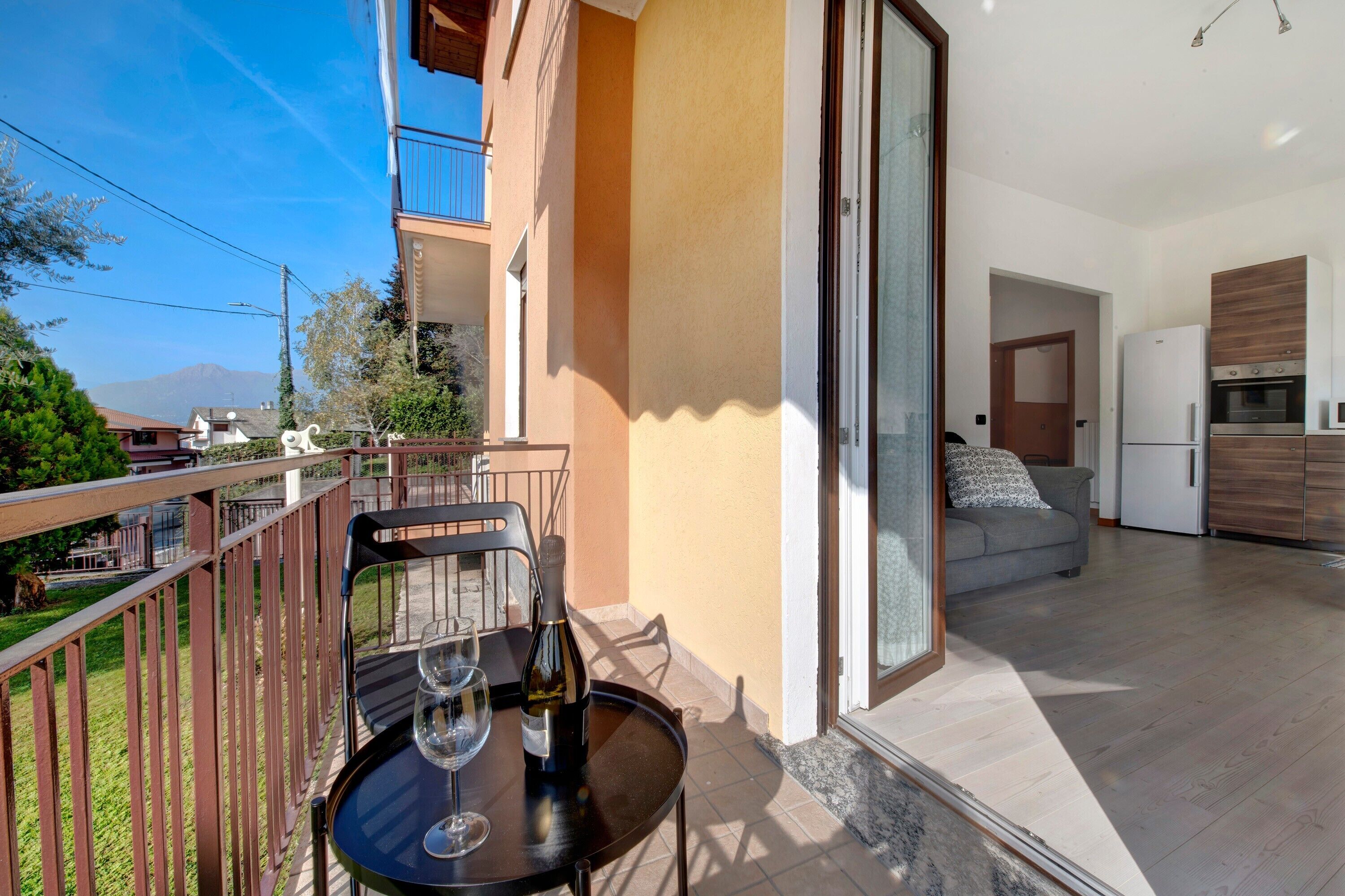 A balcony with a table, a wine bottle, and a glass.