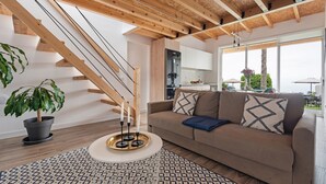 A modern living room with a staircase, a sofa, a coffee table, and a potted plant. - Holiday Home "Casa Adayeim 2" with Mountain and Sea Views (ICOD DE LOS VINOS)