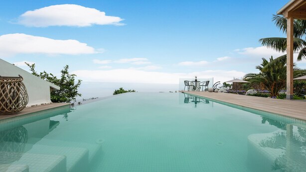 A clear swimming pool with a view of the ocean, surrounded by palm trees and a wooden deck. - Holiday Home "Casa Adayeim 2" with Mountain and Sea Views (ICOD DE LOS VINOS)