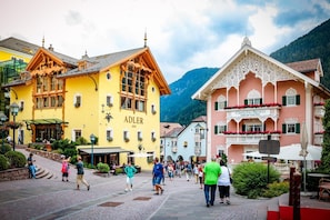 A town square with historic buildings, including a hotel named 'CAVALLINO Bianco' and a building labeled 'ADLER 1810'.