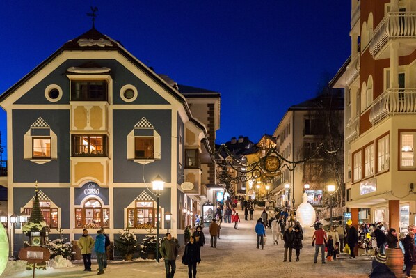 A building with a cafe sign, a Christmas tree, and a snow-covered ground.
