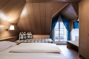 A room with two beds, a TV, and a window with curtains. - Villa Stella Apartment N 55 – Nearby Ski Lifts, Mountain View, Wi-Fi, Balcony and Garden (St.Ulrich)
