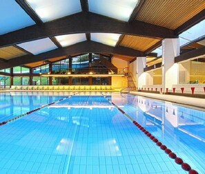 An indoor swimming pool with clear lanes, a high ceiling, and large windows. - "Villa Stella Apartment N 50" near the ski lifts with Wi-Fi and shared outdoor area (St.Ulrich)