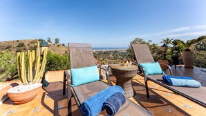 A terrace with two lounge chairs, a table, and a potted cactus. - Villa 'Cosy House Jacuzzi Wifi Pool View' with Sea View, Wi-Fi and Air Conditioning (Mijas Pueblo)