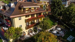 A multi-story building with balconies, a rooftop terrace, and a well-maintained garden.