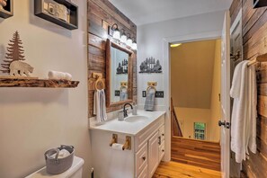 A bathroom with a wooden vanity, a large mirror, and a white sink. - Tranquil Hendersonville Cabin w/ Mountain Views! (Hendersonville)
