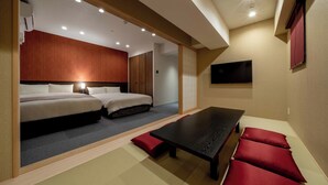 Une chambre d’hôtel avec deux lits, une table à manger et un téléviseur.