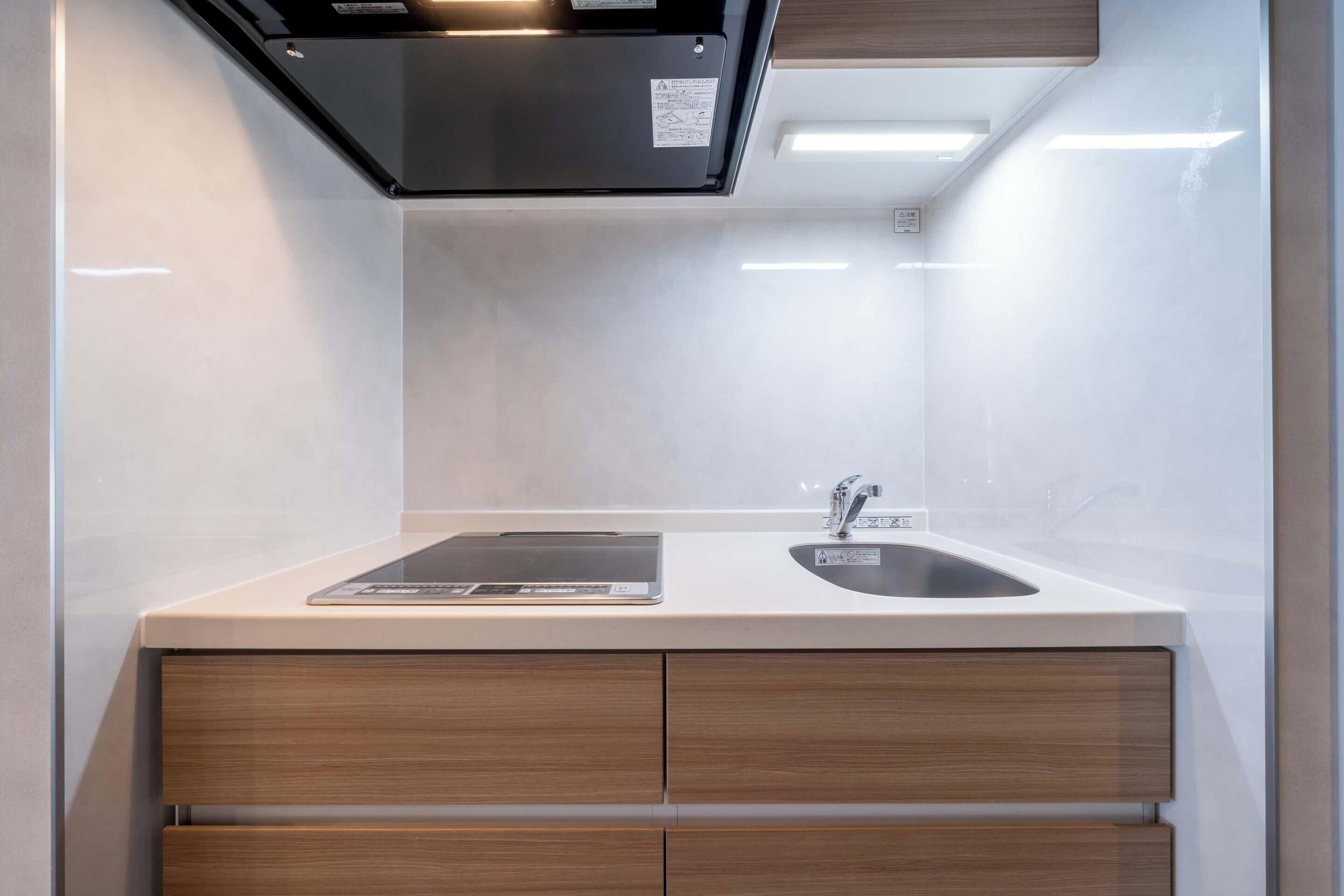 Una cocina moderna con estufa integrada, un lavamanos y una encimera con una tablet.
