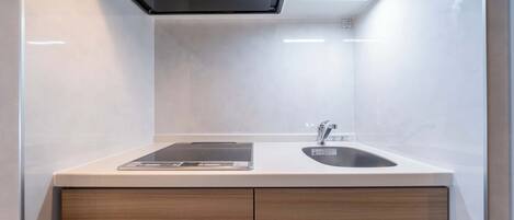 Una cocina moderna con estufa integrada, un lavamanos y una encimera con una tablet.