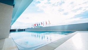 A swimming pool with a clear view of the sky and flags in the background. - Ban Ban Hotel (Phnom Penh)