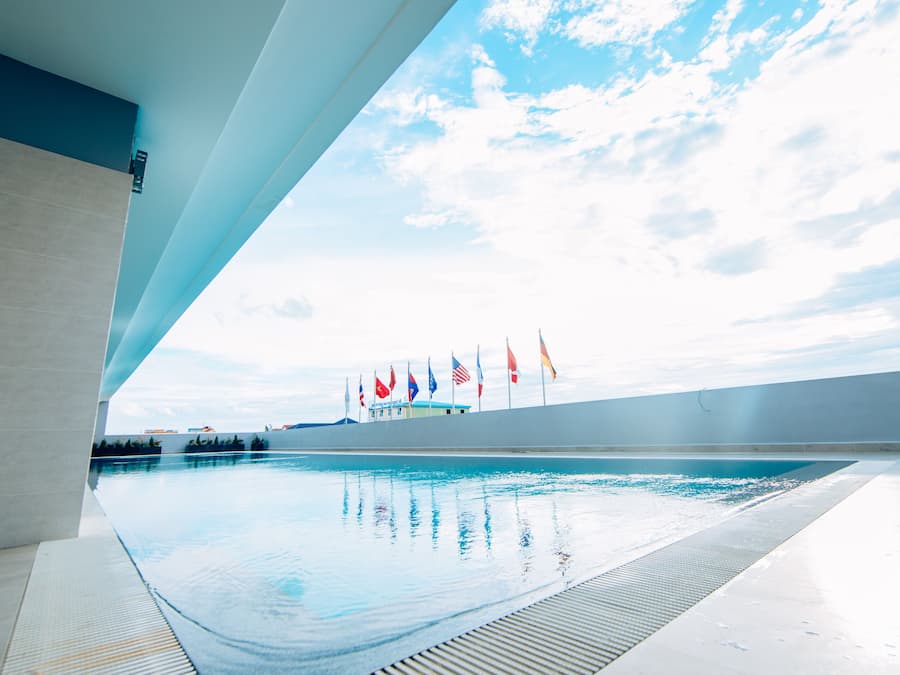 Una piscina con una vista despejada del cielo y banderas al fondo.