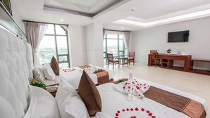 A hotel room with two beds, a dining area, and a TV. - Ban Ban Hotel (Phnom Penh)