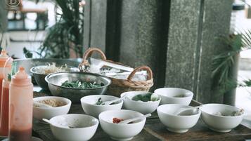 A table with various bowls and a colander, likely for a meal setting.